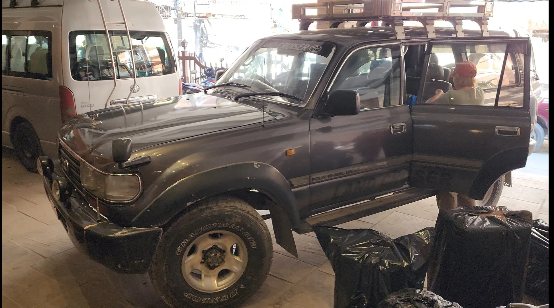 Погрузка вещей в внедорожник Land Cruiser перед выездом